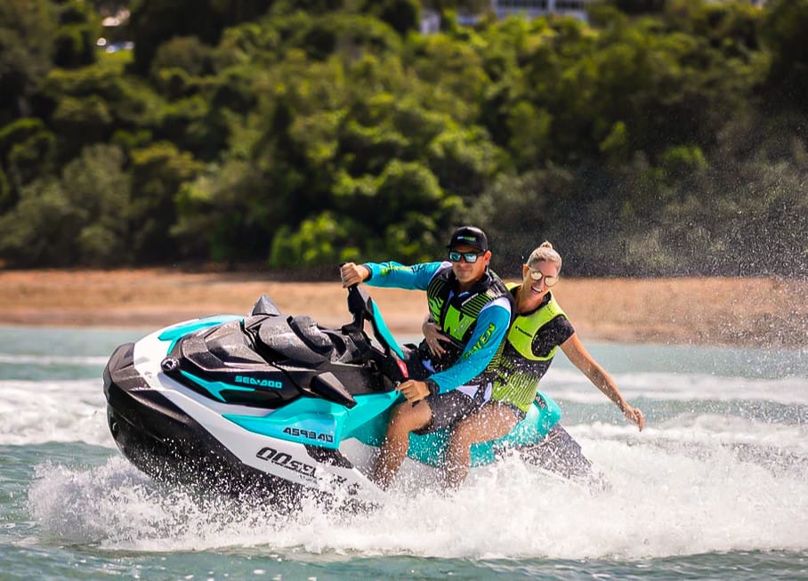 A man and a woman on a jet ski in the ocean