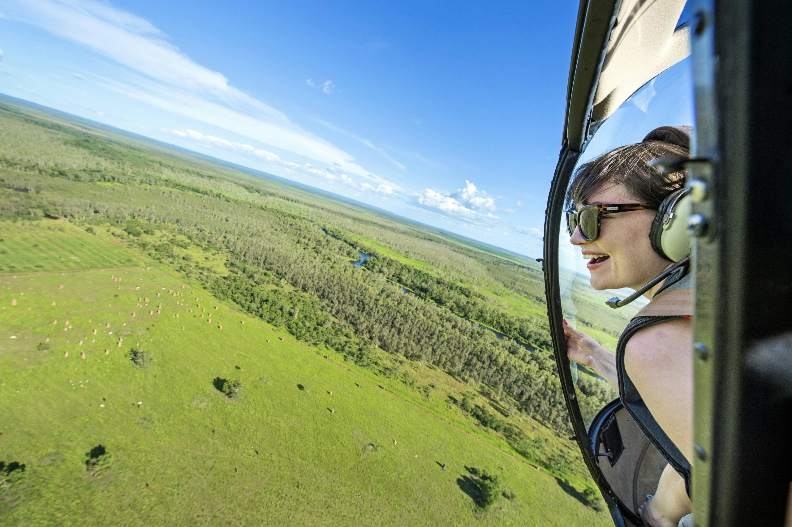 Woman flying over NT floodplains in a helicopter